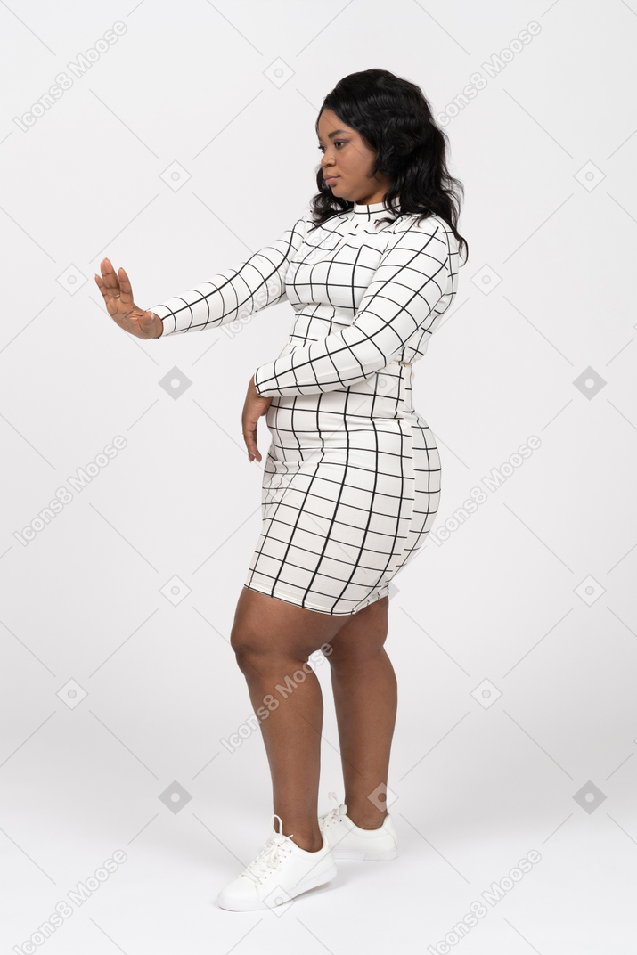 Side view of a beautiful young woman showing stop gesture