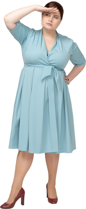 Vista frontal de una mujer con vestido azul en busca de alguien