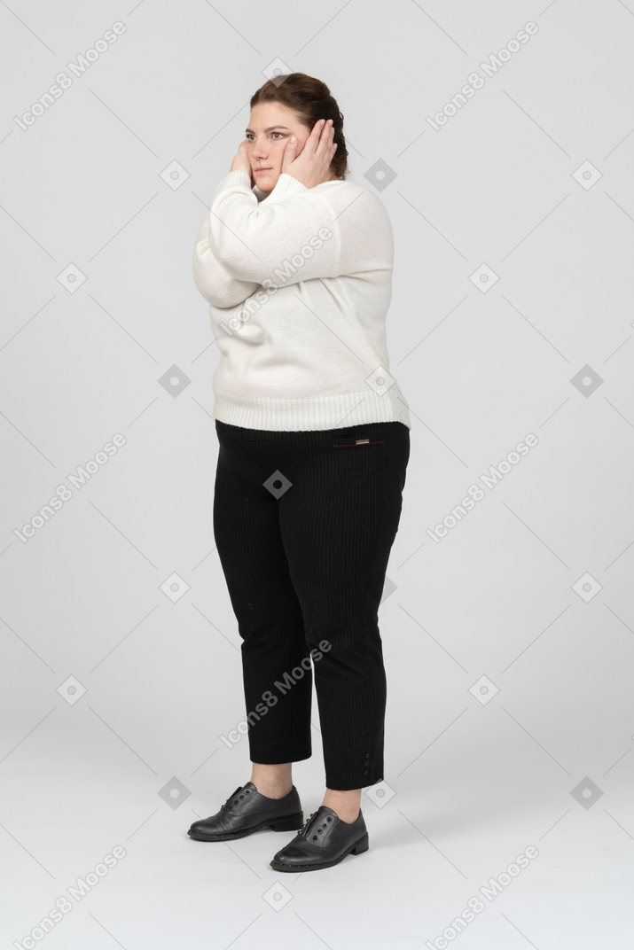 Side view of a plump woman in casual clothes closing ears