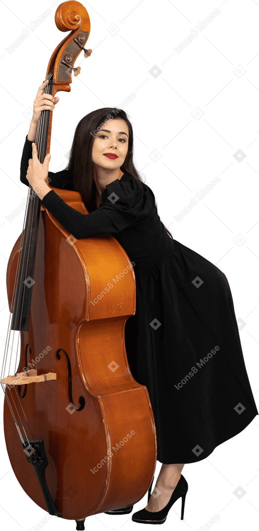 Vista di tre quarti di una giovane musicista in abito nero che tiene il suo contrabbasso proteso in avanti
