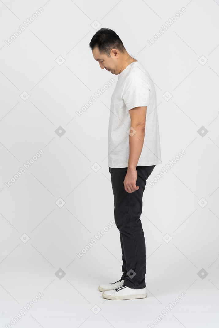 Side view of a man in casual clothes bending head down