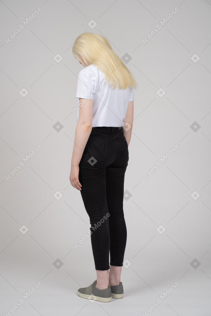 Three-quarter back view of a teenage girl with her head down