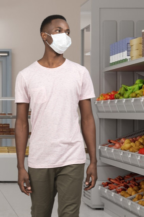 Homme portant un masque facial dans le supermarché