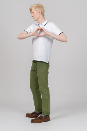 Young man showing a heart sign with his fingers