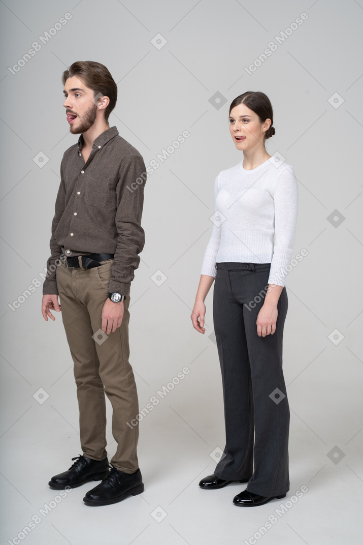 Three-quarter view of a young couple in office clothing licking lips