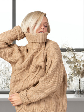 Junge frau, die einen gestrickten pullover trägt