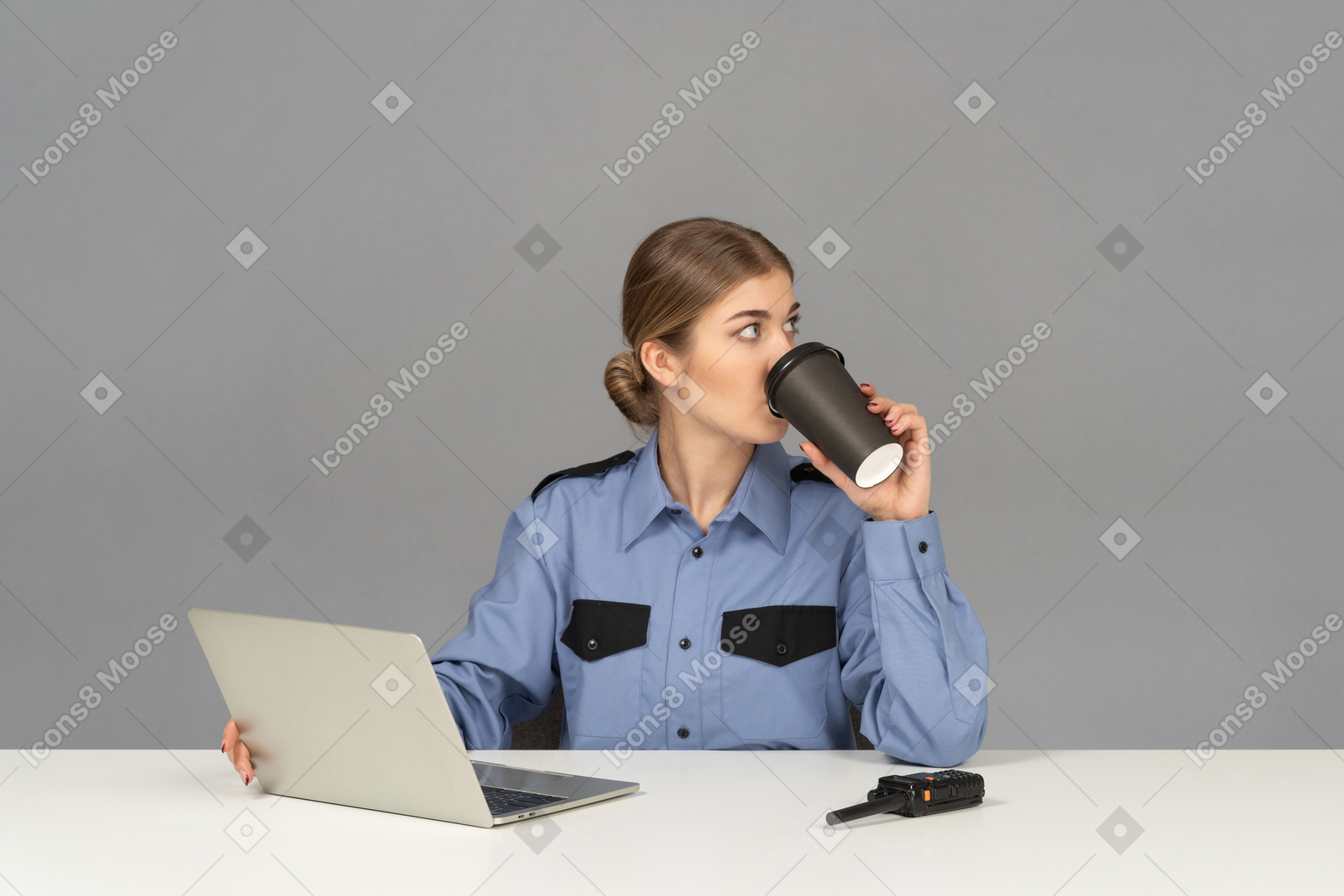 A female security guard drinking a coffee