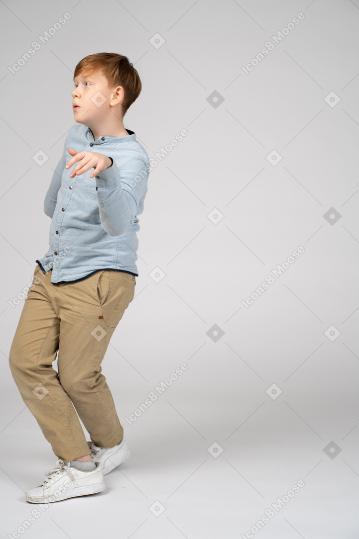 A young boy in a blue shirt doing a pose