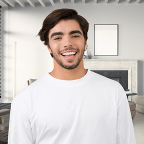 A man in a white long - sleeve shirt standing in front of a living room