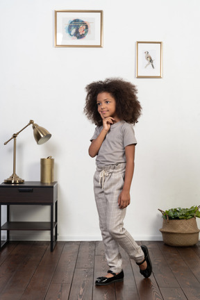 Good looking girl kid posing on the apartment background