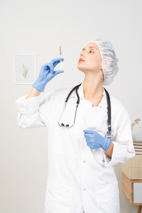 Front view of a young female doctor holding a syringe