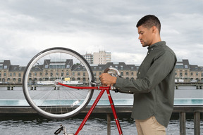 Mann, der mit seinem fahrrad auf einer brücke steht