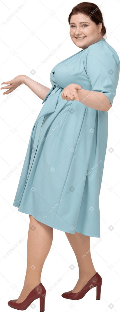 Side view of a happy woman in blue dress gesturing