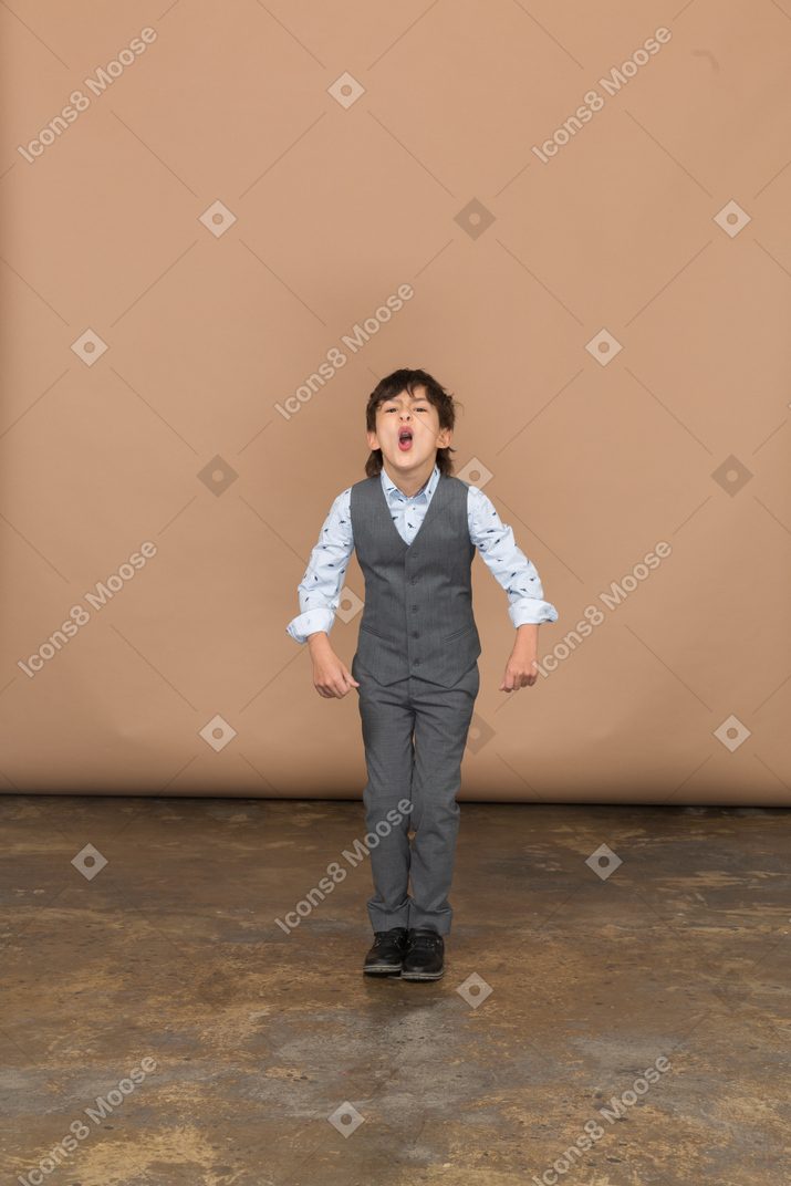 Front view of a cute boy in suit ready to jump