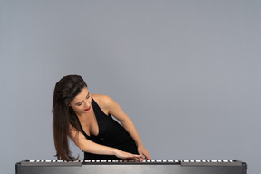 Pianista femenina apasionada deslizando las teclas del piano