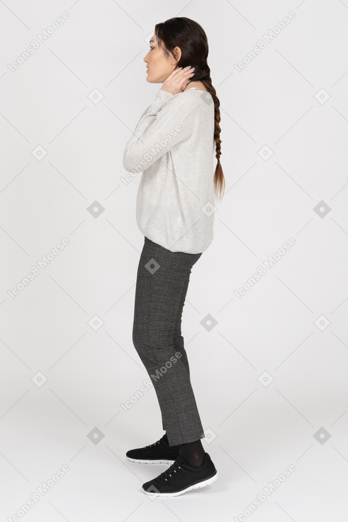 Concerned woman with a long plait touching her neck
