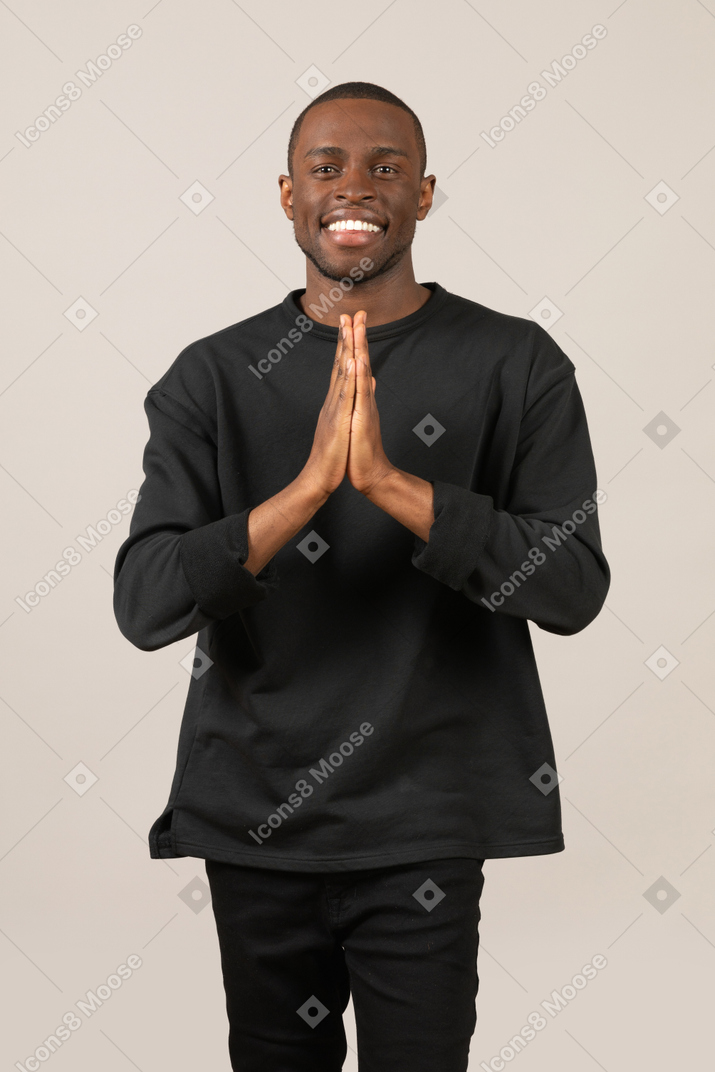 Happy smiling young man with folded hands