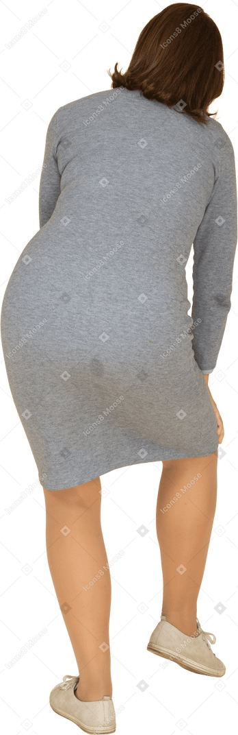 膝に触れる灰色のドレスを着た女性の背面図