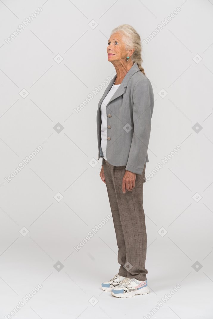 Anciana en chaqueta gris de pie de perfil