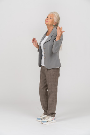 Side view of a happy old lady in suit gesturing