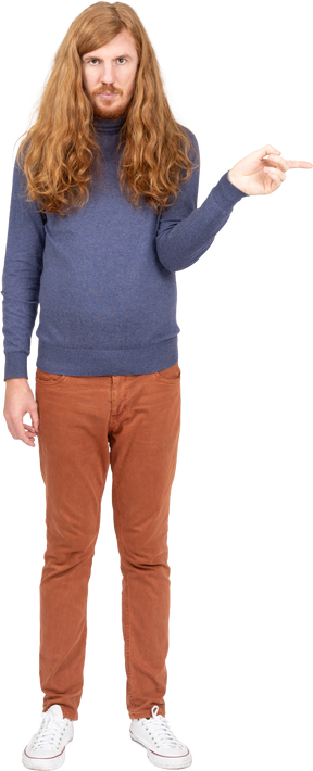 Вид спереди молодого человека в повседневной одежде, указывающего пальцем