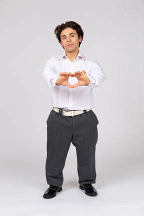 Young man showing a heart sign with hands