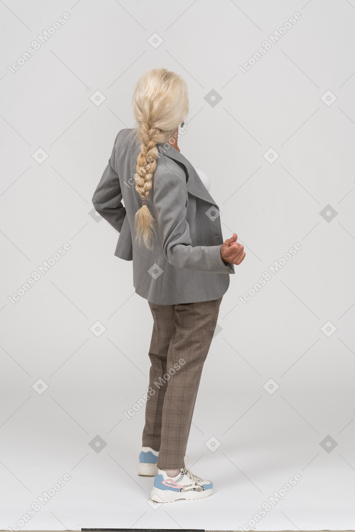 Rückansicht einer alten dame im anzug, die sich nach hinten beugt