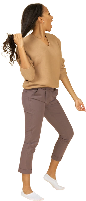 Side view of a dark-skinned screaming young lady grabbing her hair
