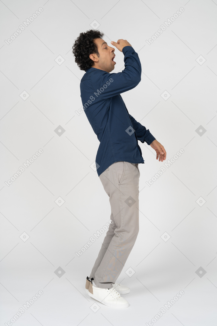 Side view of a man in casual clothes sneezing