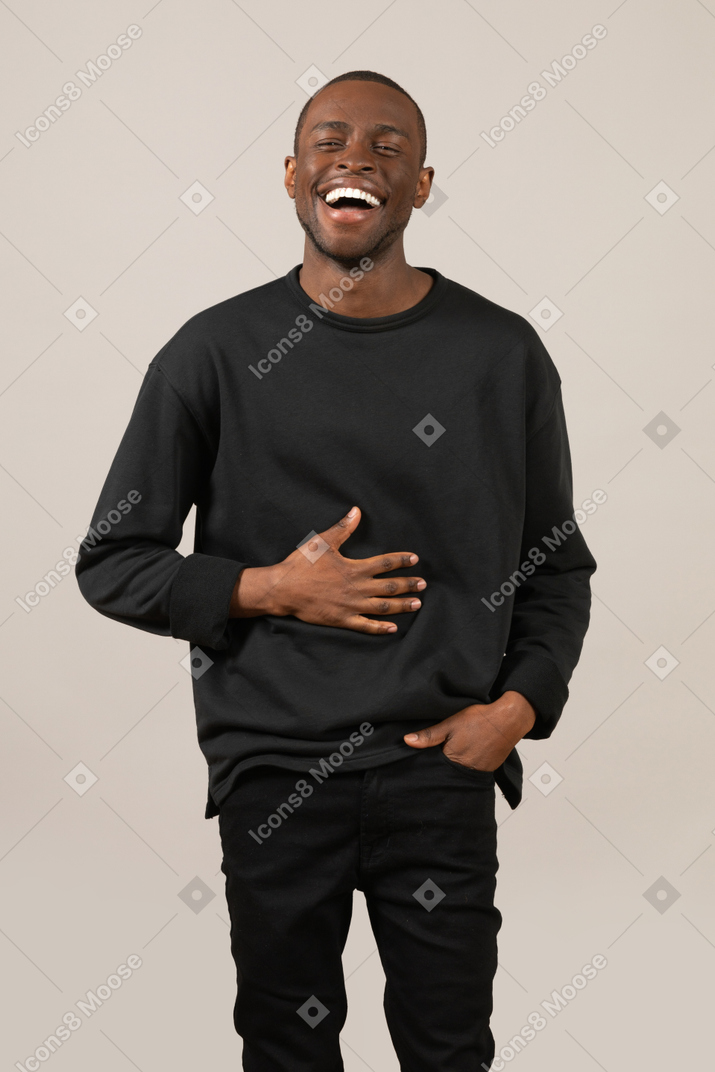 Young man laughing and holding his stomach