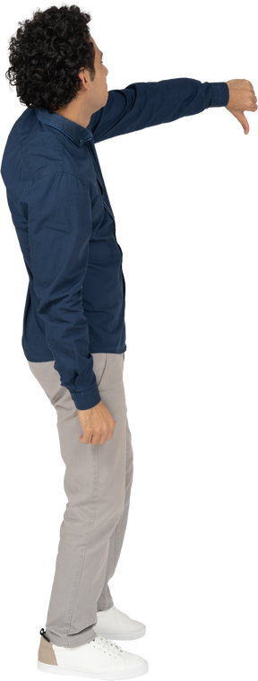 Vista lateral de um homem com roupas casuais mostrando o polegar para baixo