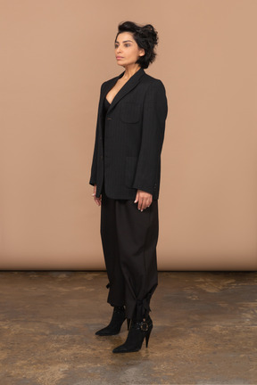 A woman standing in a room wearing a black suit