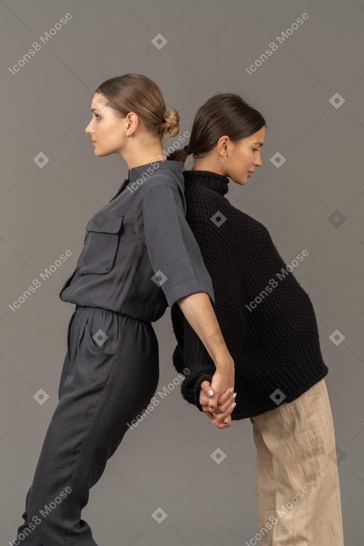 Dos mujeres de pie espalda con espalda