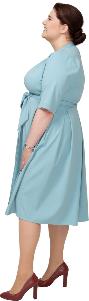 Вид сбоку счастливой женщины в синем платье