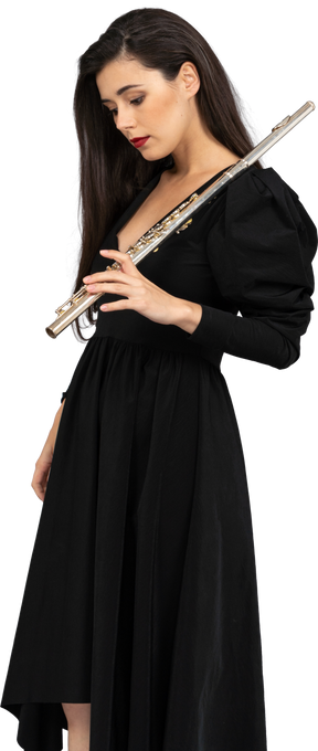 Vista frontal de uma jovem de vestido preto segurando uma flauta
