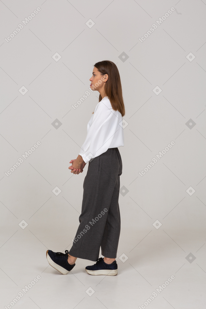 一位穿着办公室服装的不高兴的年轻女士手牵着手的侧视图