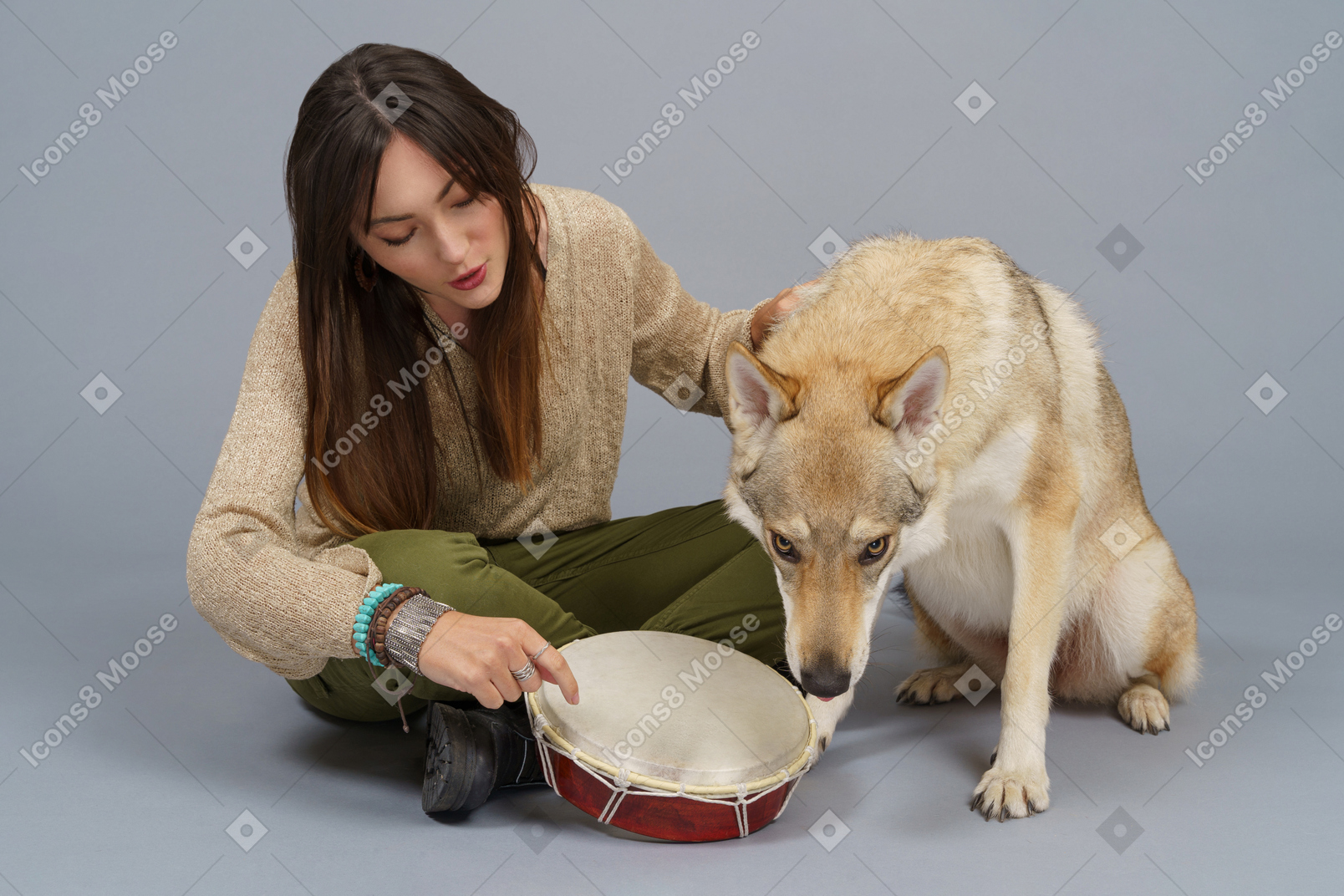 Full-length of a female master and her dog smelling a drum