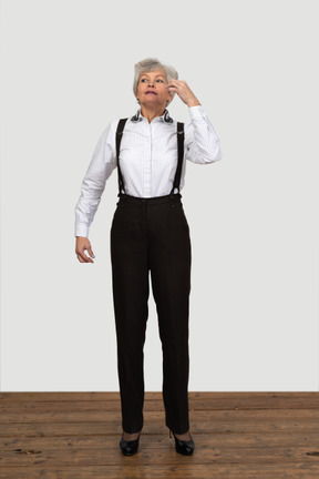 Vista frontale di una donna anziana in abiti da ufficio in attesa di qualcosa al chiuso
