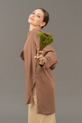 Jeune femme souriante avec des fleurs de prairie