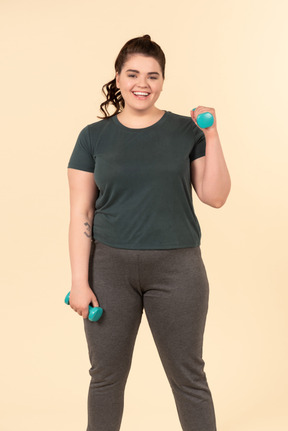 Mujer joven de talla grande con ropa deportiva haciendo ejercicios físicos