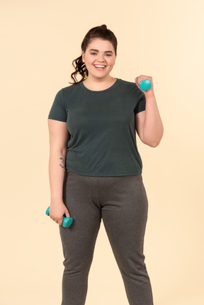 Young plus size woman in sport clothes doing physical exercises