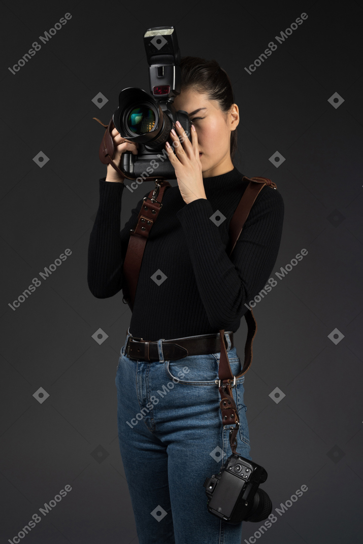 Young female photographer being wrapped up in work