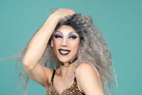 Colpo alla testa di una drag queen che sorride con la mano sopra la testa