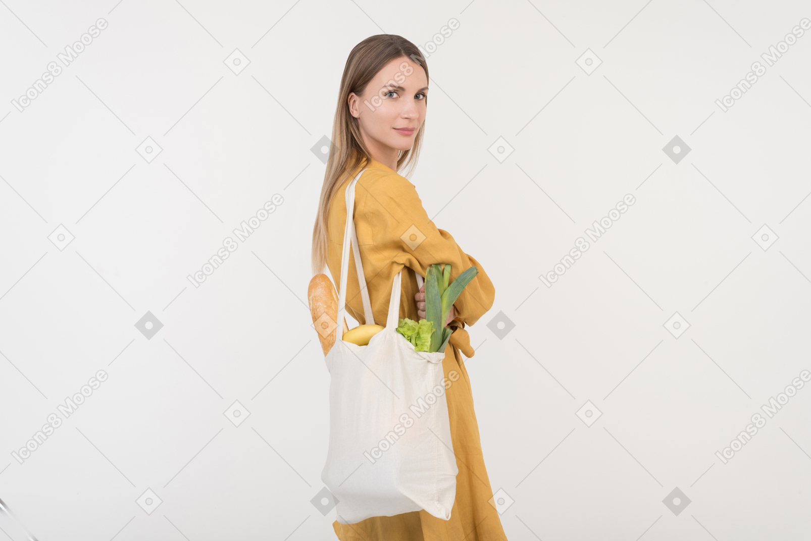 Young woman holding reusable shopping bag with vegetables