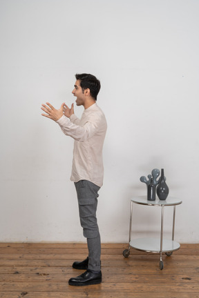 Side view of a happy man in casual clothes gesturing