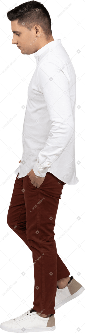 一个年轻的拉丁裔男子双手插在口袋里向前迈进的侧视图