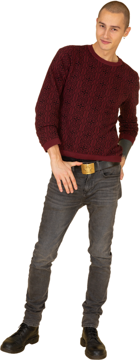 Front view of a young man in red pullover touching his belt