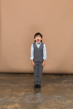 Front view of a boy in suit looking up