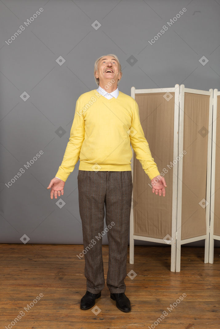 Front view of an astonished old man outspreading his hands