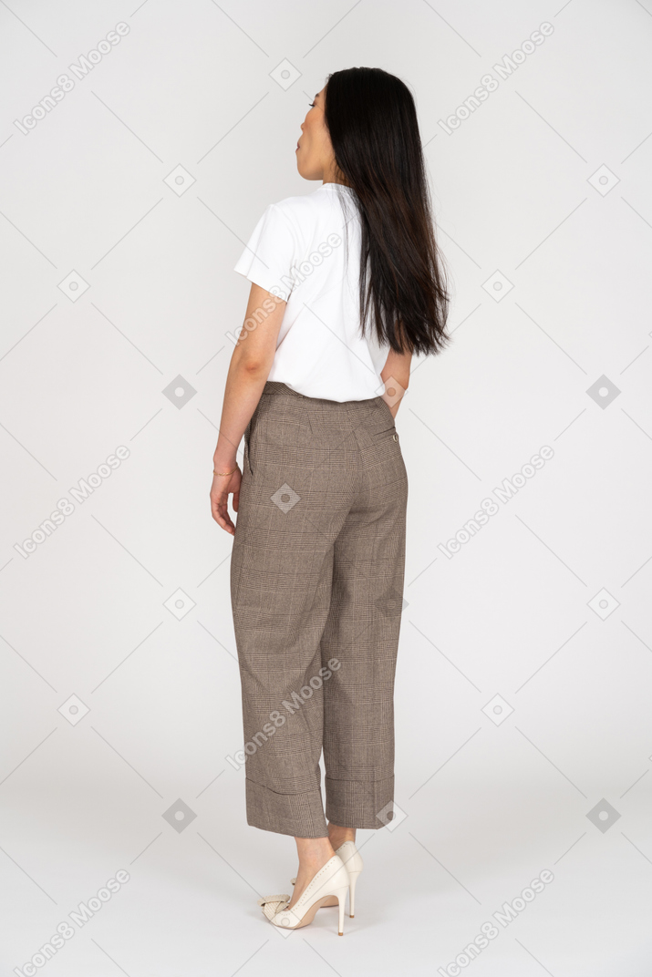 Three-quarter back view of a surprised young woman in breeches